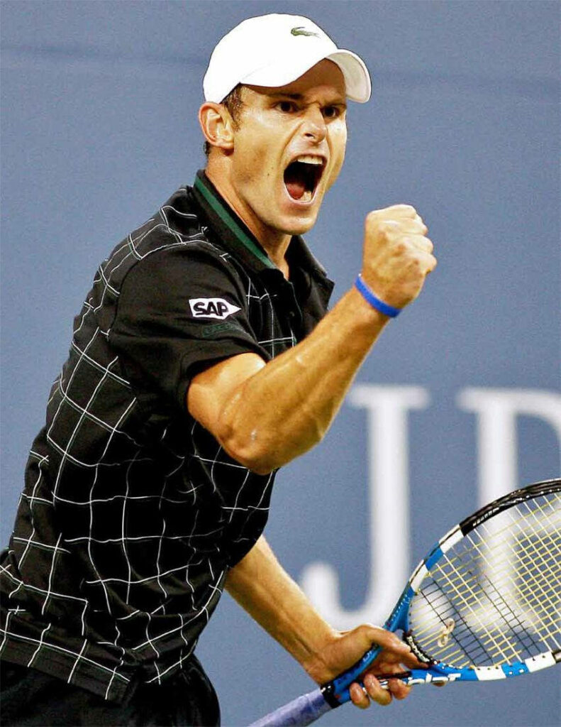 Andy Roddick celebrates passionately on tennis court with fist raised showing determination Wallpaper
