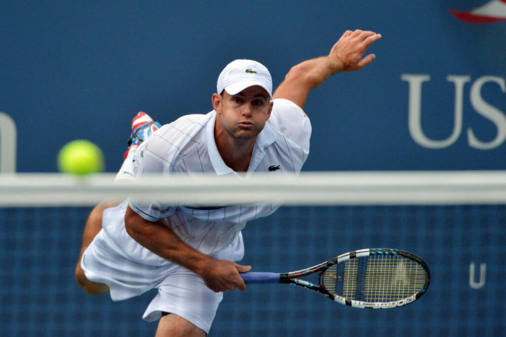 Andy Roddick lunges forward intensely to return a tennis shot in a competitive match wallpaper