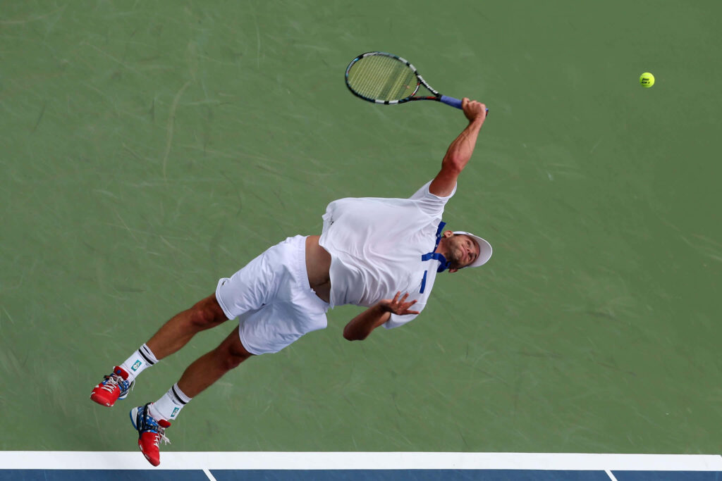 Andy Roddick mid-air powerful tennis serve showcasing athleticism intensity wallpaper background