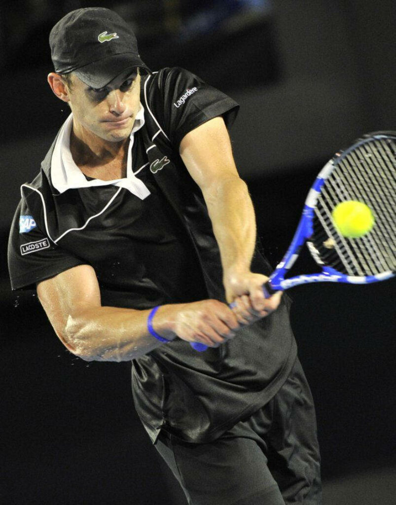 Andy Roddick hitting powerful sideways backhand on tennis court showing focus and athleticism Wallpaper