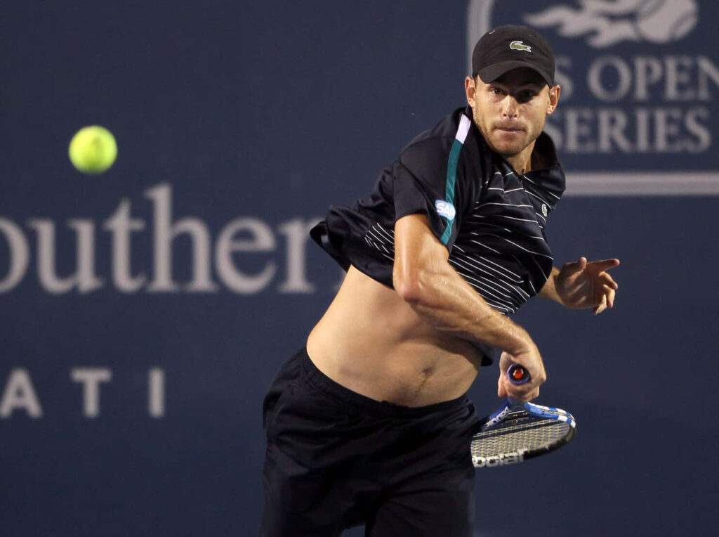 Andy Roddick in intense action after powerful tennis shot displaying athleticism on court wallpaper