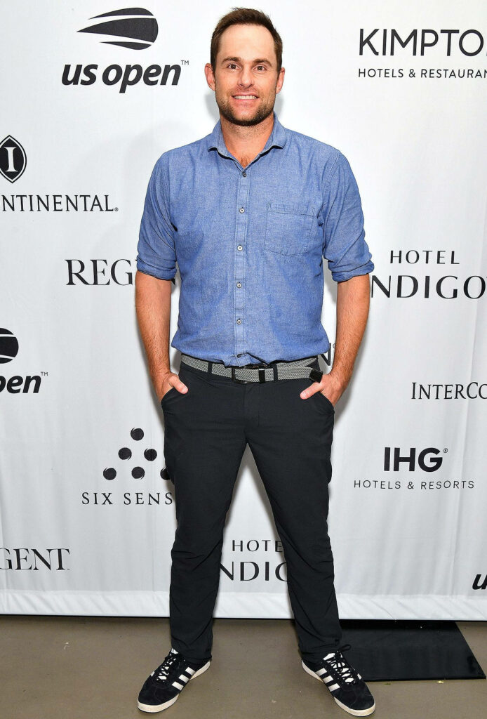 Andy Roddick confident pose US Open casual blue shirt dark pants sponsor logo backdrop wallpaper