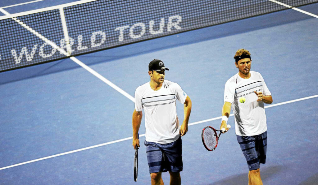 Andy Roddick and doubles partner in matching outfits walking on blue hard tennis court tournament Wallpaper