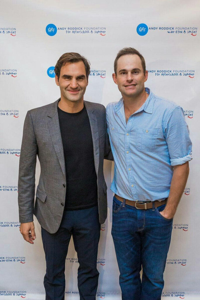 Andy Roddick and Roger Federer at Andy Roddick Foundation event with logo backdrop wallpaper