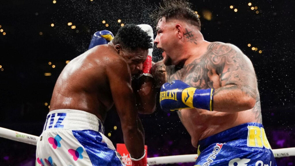 Andy Ruiz Jr. lands a powerful punch on Ortiz in an intense boxing match wallpaper background