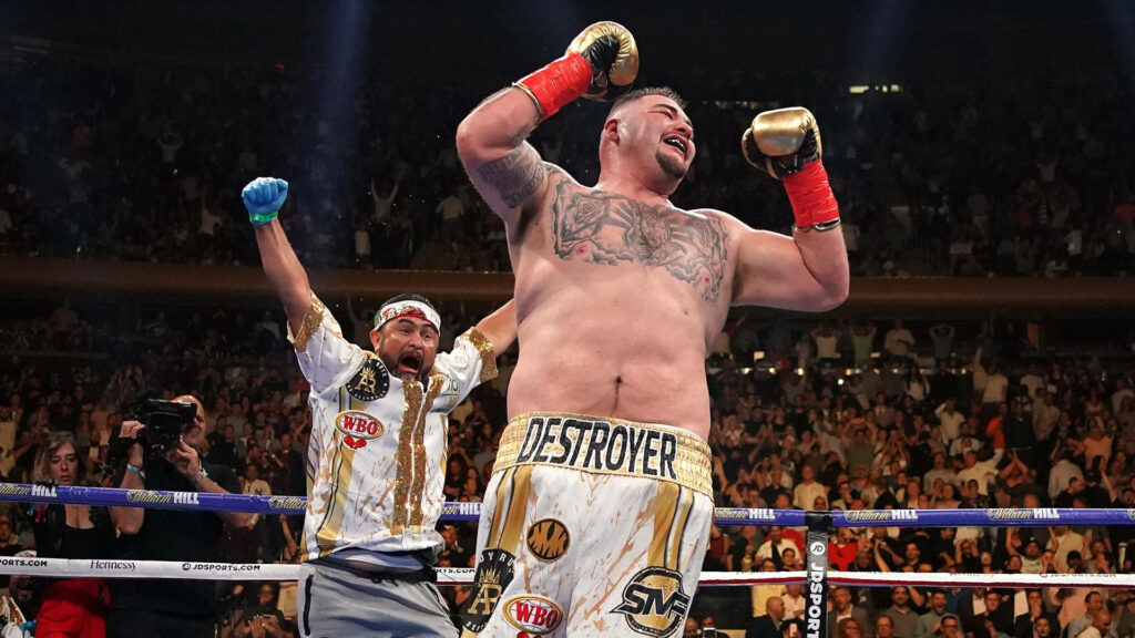 Andy Ruiz Jr celebrating boxing victory in ring with cheering fans and team background wallpaper