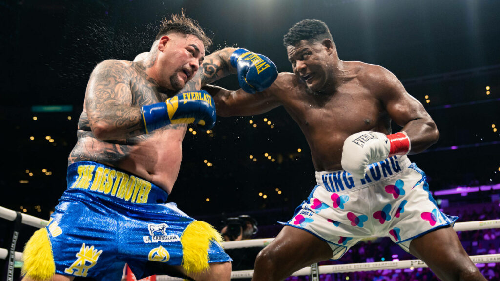 Andy Ruiz Jr and Luis Ortiz exchange powerful punches in intense boxing match under arena lights Wallpaper
