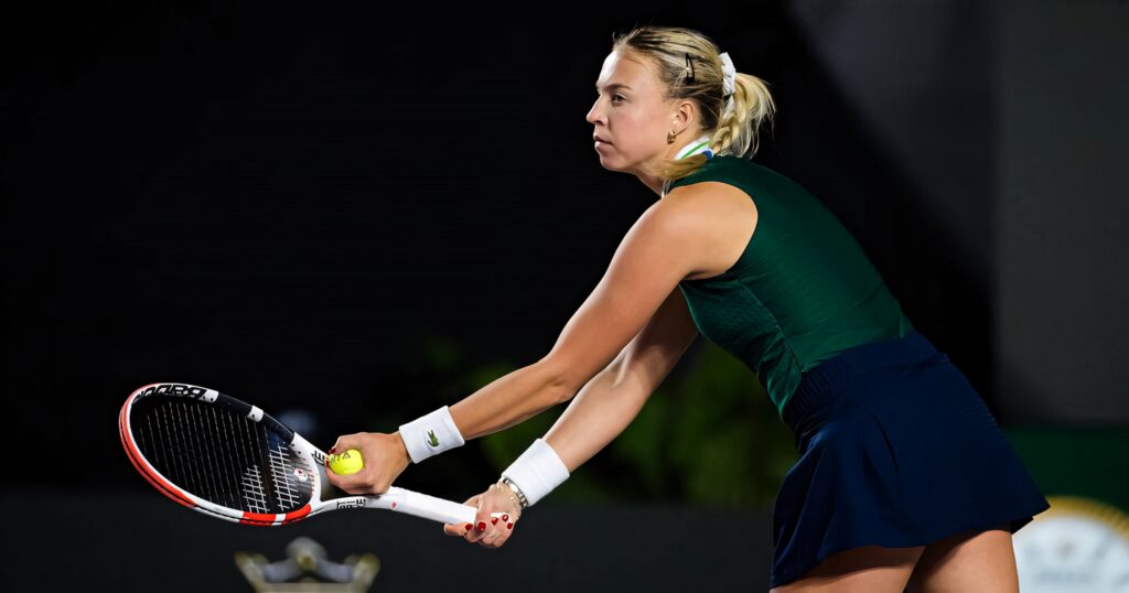 Anett Kontaveit focused at baseline preparing to serve in intense professional tennis match wallpaper