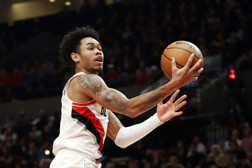 Anfernee Simons driving for a dynamic layup basketball game action athletic wallpaper background