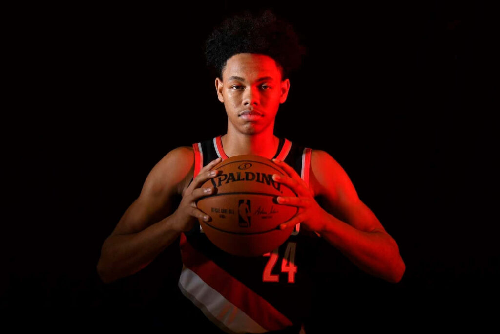 Anfernee Simons holding basketball with intense focus dramatic lighting dark background wallpaper