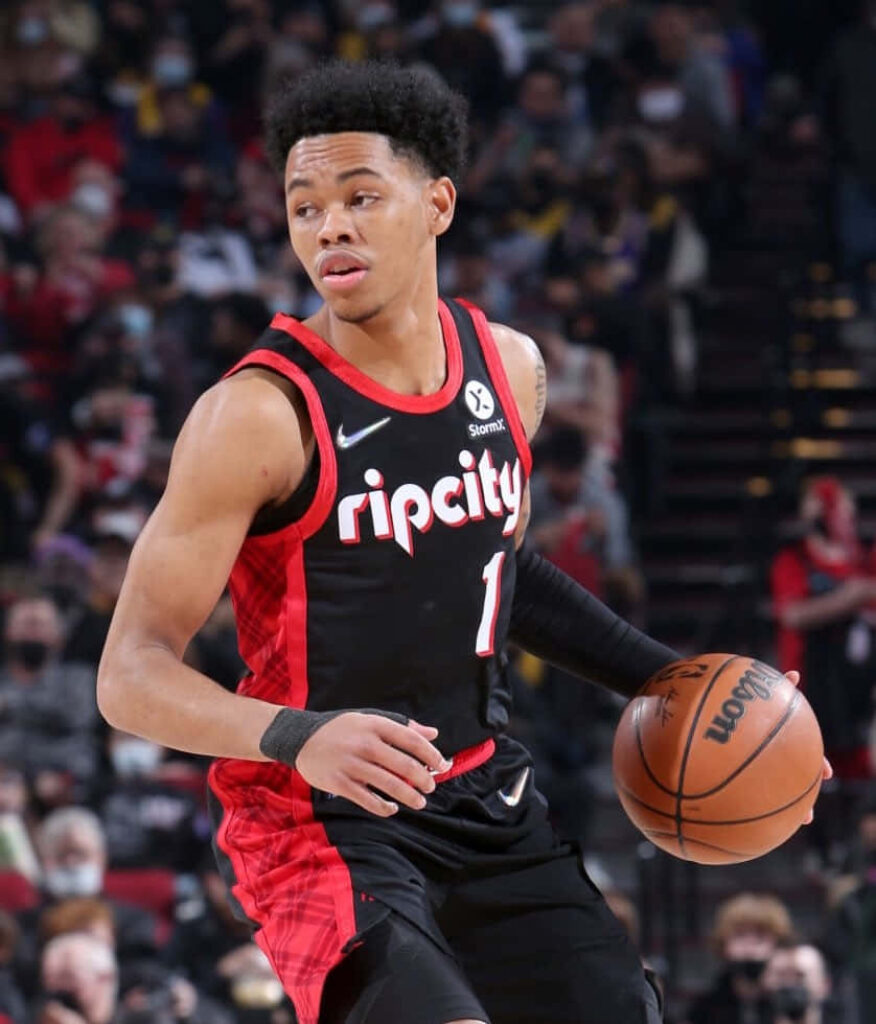 Anfernee Simons dribbling basketball in Portland Trail Blazers uniform during game action Wallpaper