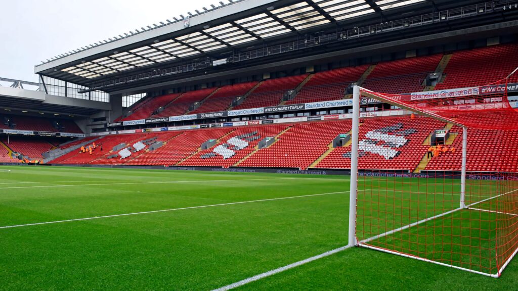 Anfield Stadium interior with vibrant red seats and green pitch iconic Liverpool FC home view Wallpaper