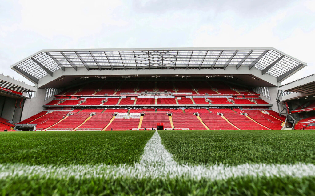Anfield Stadium interior with vibrant red seats and modern stands viewed from the pitch Wallpaper