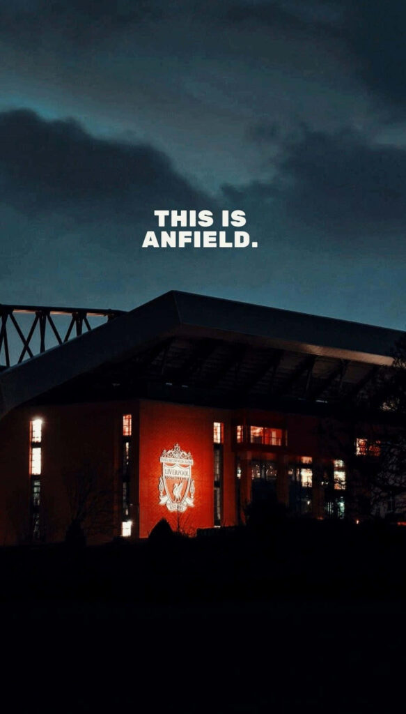 Anfield Stadium glowing at night with illuminated Liverpool FC crest football wallpaper background