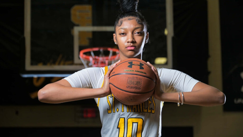 Angel Reese in St Frances uniform holding basketball confident pose gym wallpaper background