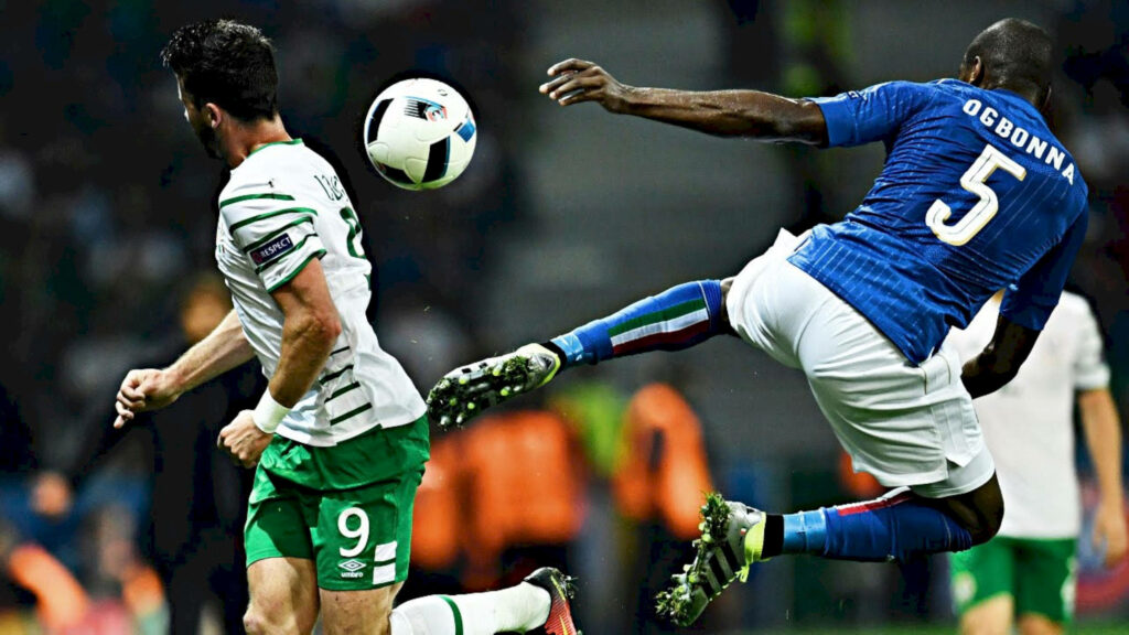 Angelo Ogbonna making a powerful defensive play in an intense soccer match wallpaper background