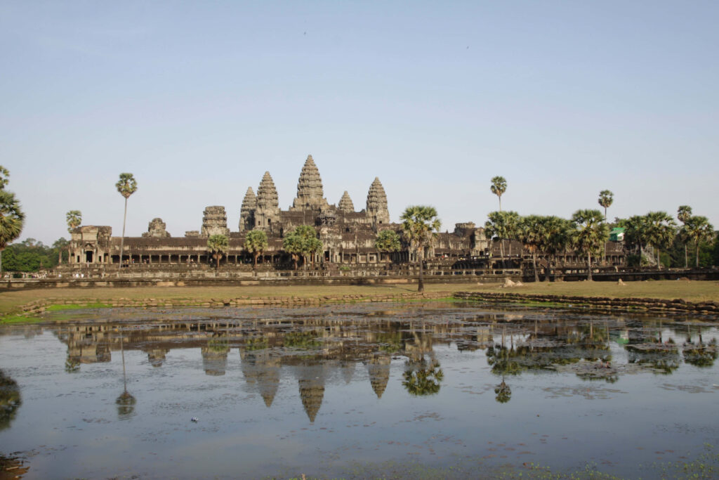 Angkor Thom temple complex spires reflected in calm pond under clear sky Cambodia wallpaper