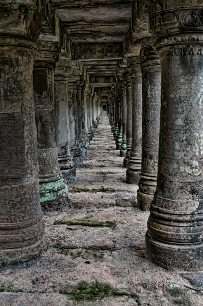 Ancient stone pillars and long corridor of Angkor Wat showcasing historic temple architecture wallpaper