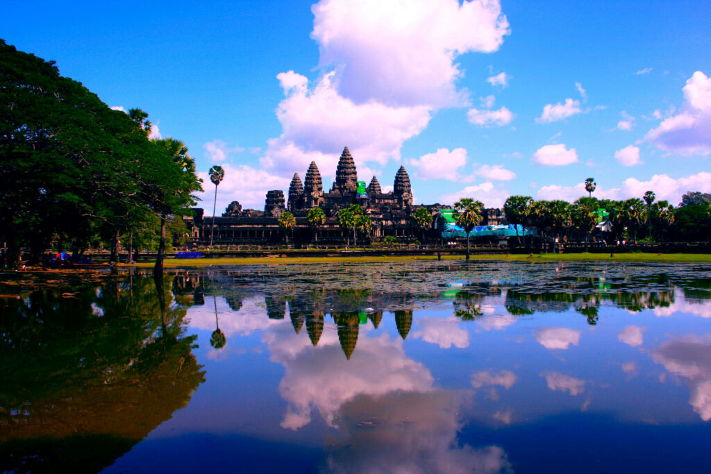 Angkor Wat temple reflected on calm water under vibrant pink and blue sky at sunset wallpaper
