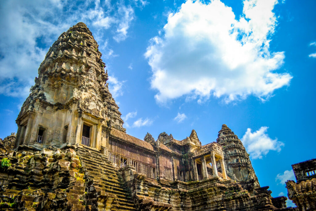 Angkor Wat temple under bright blue sky with dramatic clouds ancient architecture wallpaper