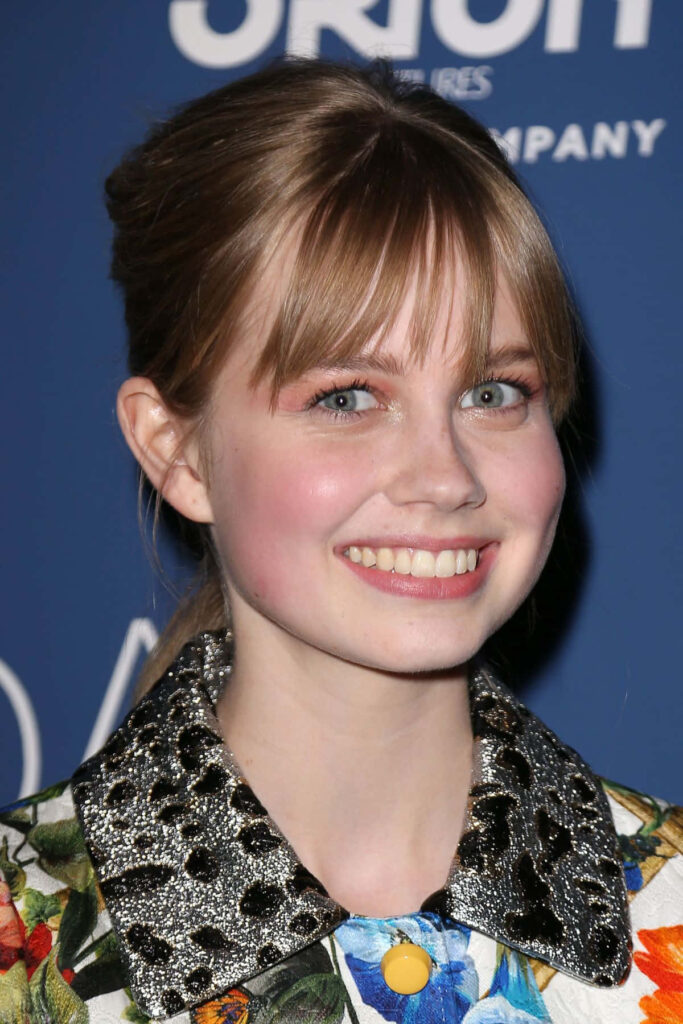 Angourie Rice smiling brightly in polished portrait wallpaper background at event