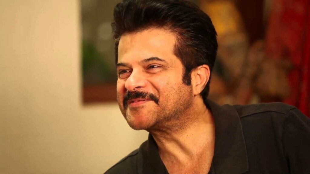 Anil Kapoor smiling warmly in vibrant colorful wallpaper background cheerful portrait
