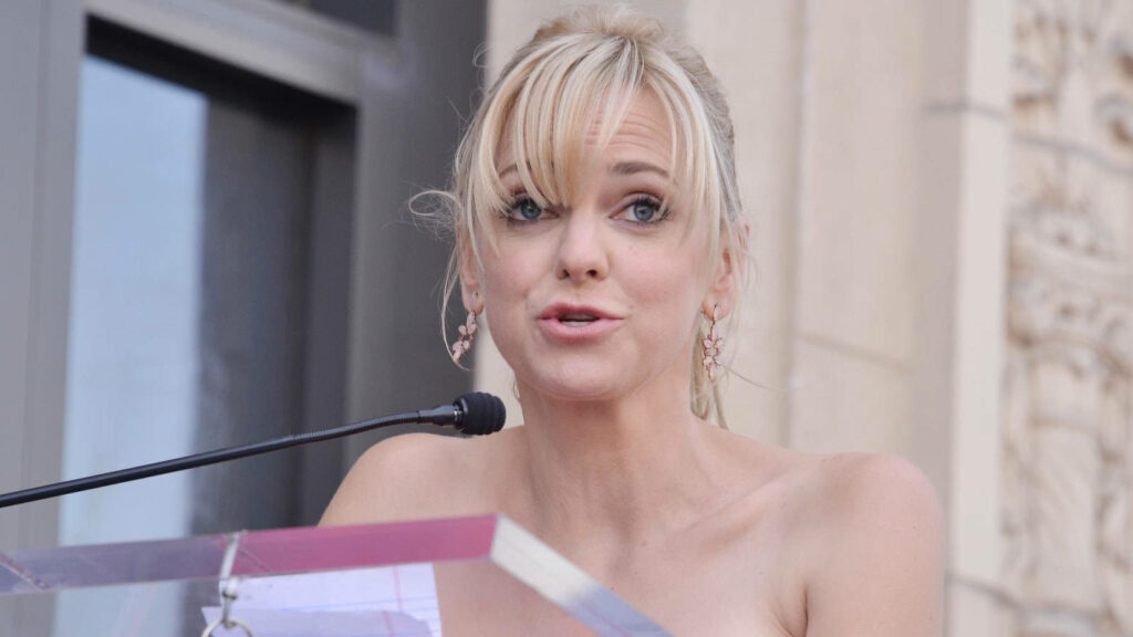 Actress Anna Faris delivering outdoor speech at clear podium with historic building backdrop wallpaper