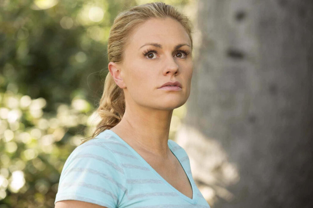 Anna Paquin outdoors with concerned expression surrounded by lush natural greenery background Wallpaper