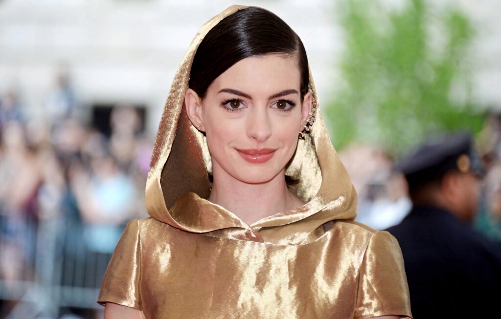 Anne Hathaway in glamorous golden robe elegant sophisticated wallpaper background image