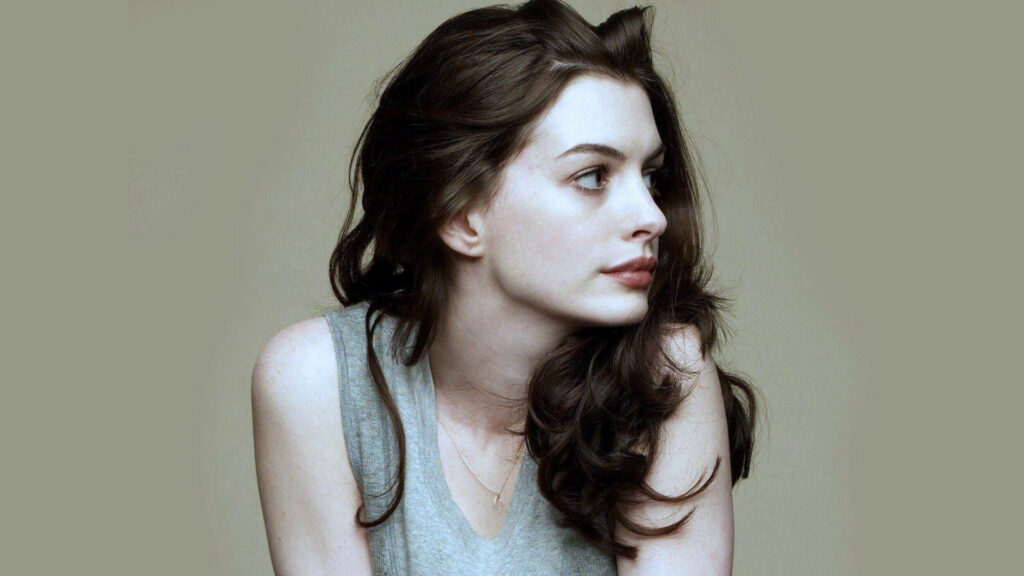 Side profile of Anne Hathaway with natural beauty and elegant expression on soft neutral background Wallpaper