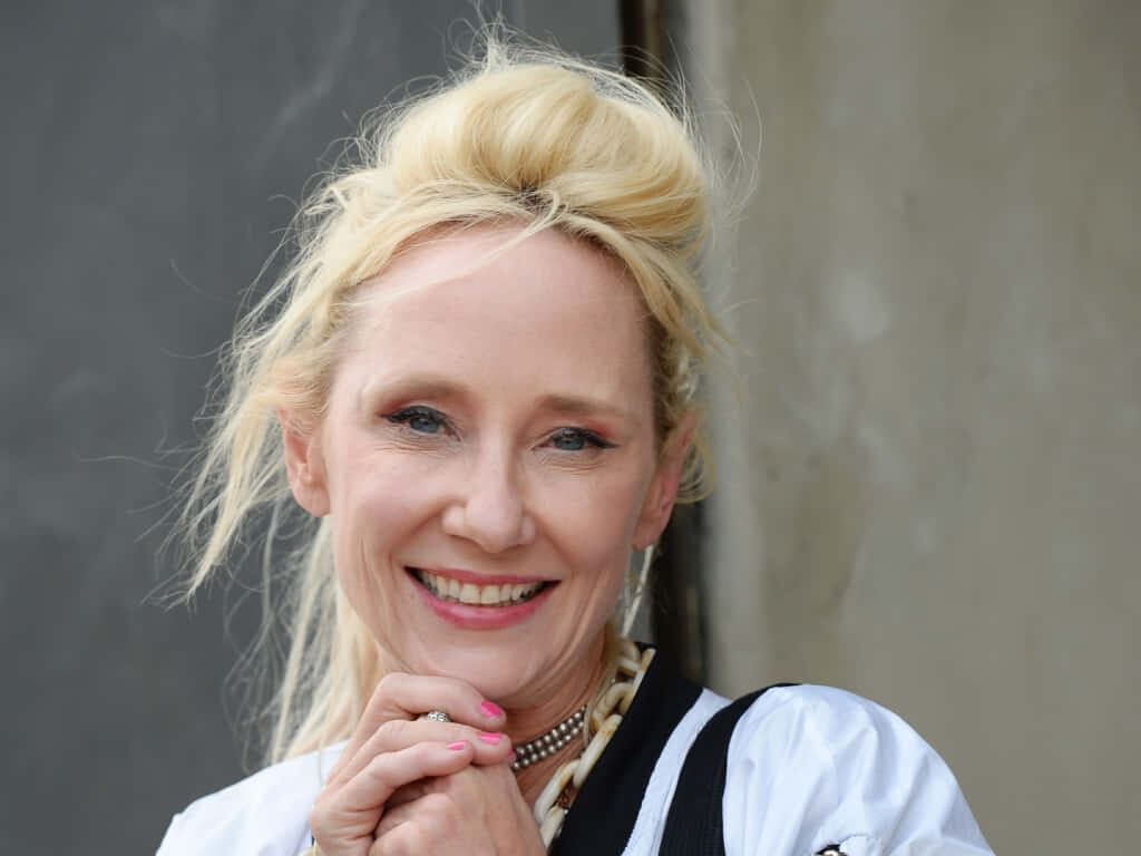 Anne Heche joyful smiling portrait wallpaper radiating warmth happiness and relaxed pose background