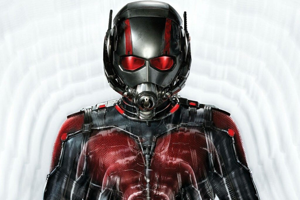 Ant Man in detailed high tech suit with red accents standing confidently on bright background Wallpaper