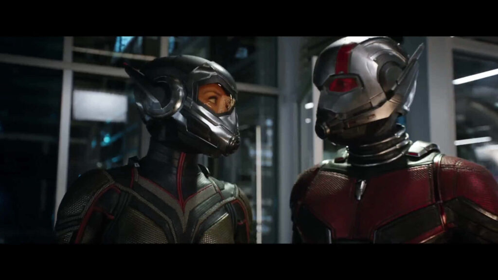 Ant Man and Wasp in advanced suits poised for action inside high tech laboratory wallpaper