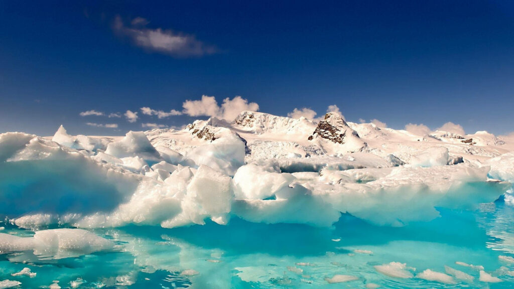 Antarctica wallpaper with turquoise water ice formations snow mountains vivid blue sky background