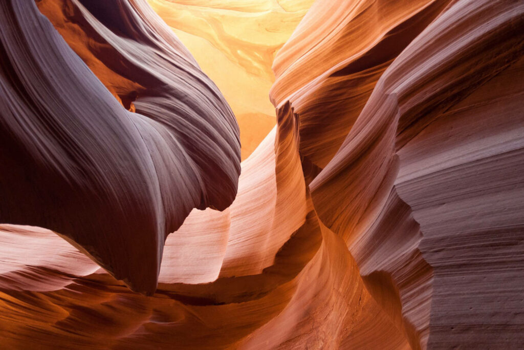Antelope Canyon smooth flowing sandstone walls with warm sunlight creating glowing rock formations Wallpaper