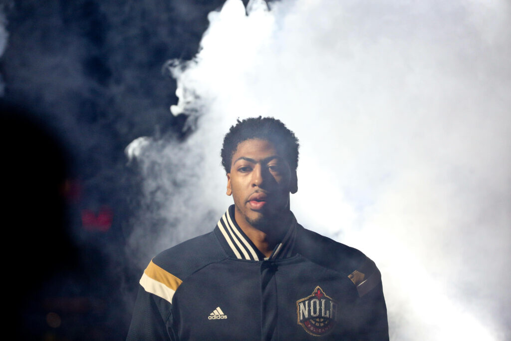 Anthony Davis in New Orleans All Star jacket emerging through smoke ready to dominate basketball court Wallpaper