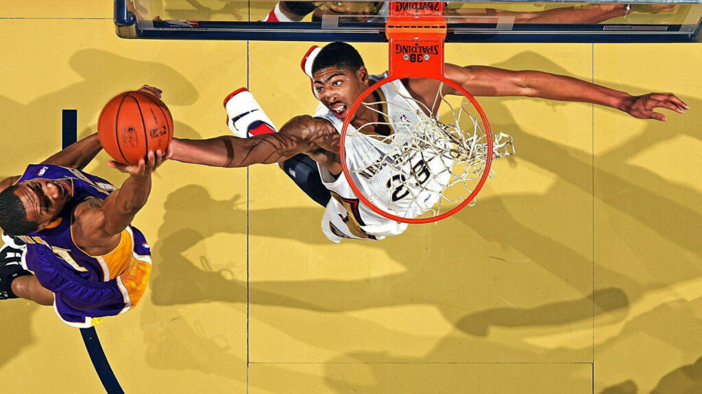 Anthony Davis jumping high for a rebound showing athleticism and defense in NBA game wallpaper