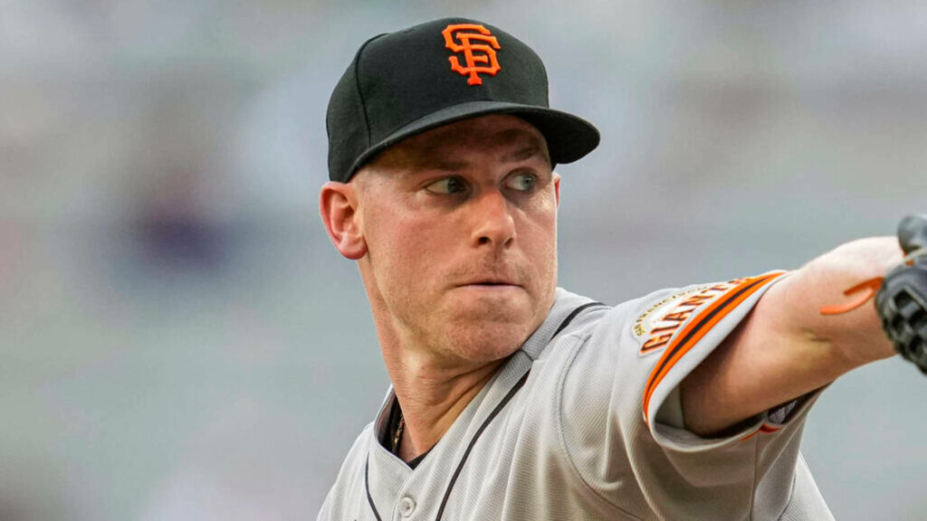 Anthony DeSclafani in San Francisco Giants uniform pitching on baseball field with wallpaper background
