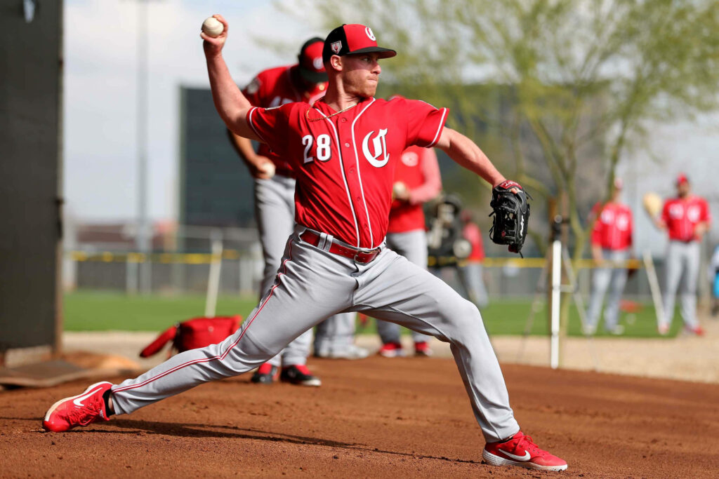 Cincinnati Reds pitcher Anthony Desclafani mid-windup on sunlit baseball field vibrant action Wallpaper