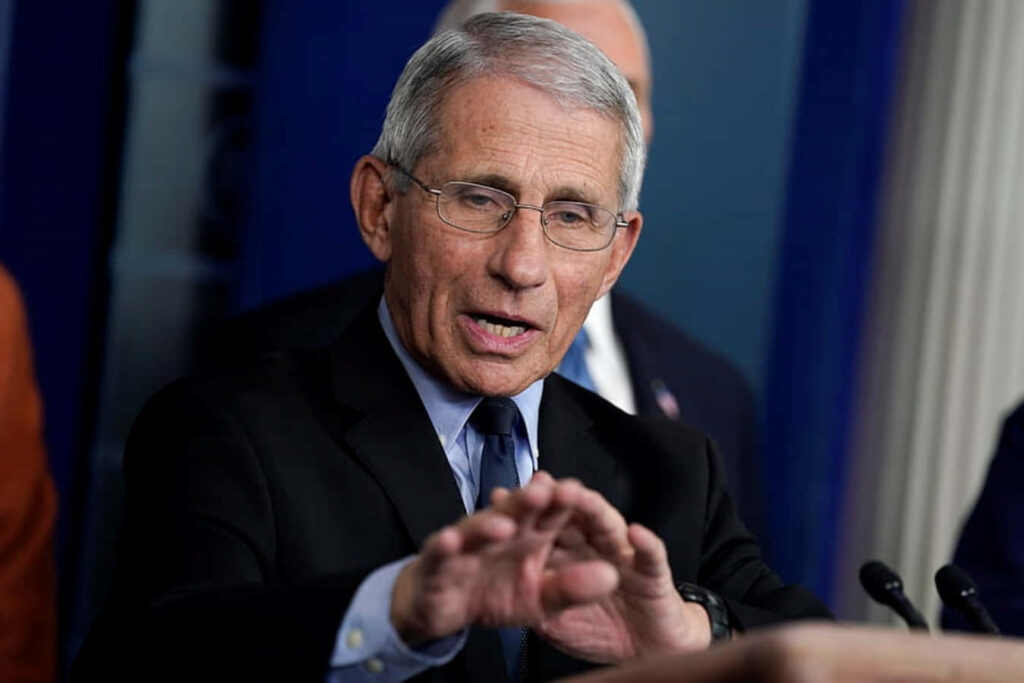 Anthony Fauci speaking at press conference focused immunologist in suit wallpaper background