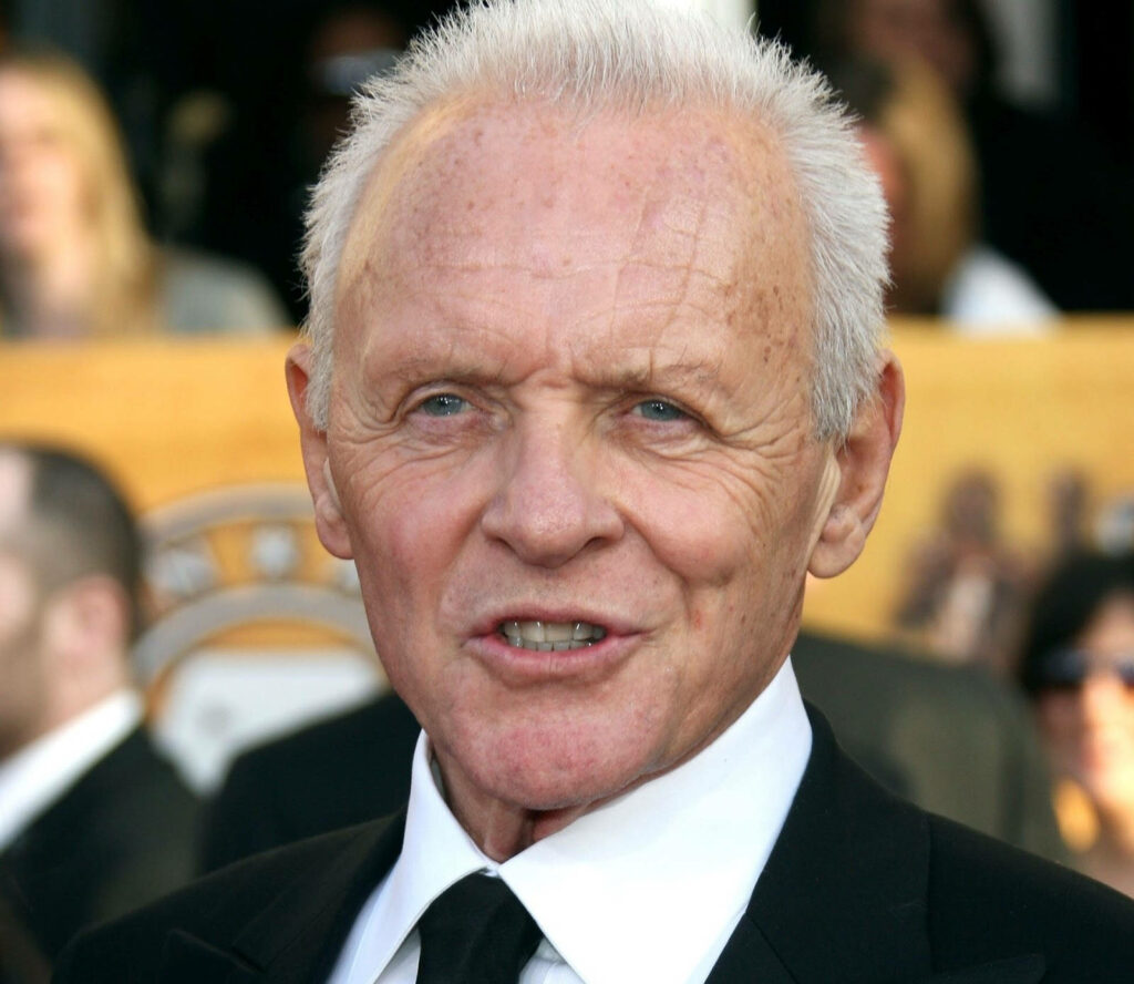 Anthony Hopkins in classic suit mid-interview focused expression high-quality wallpaper background