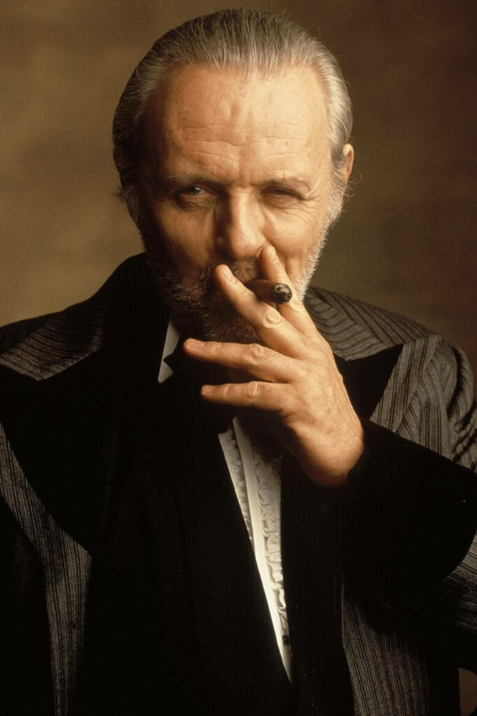 Anthony Hopkins in classic suit holding cigar with intense thoughtful expression wallpaper