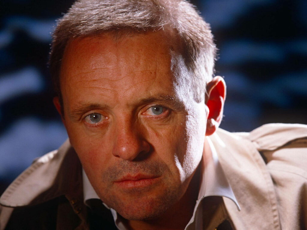 Close-up portrait of young Anthony Hopkins with intense blue eyes and serious expression wallpaper
