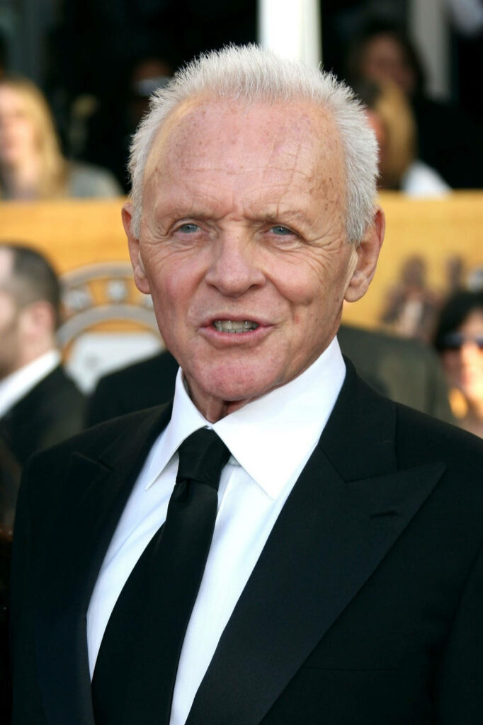 Anthony Hopkins intense expression black suit and tie iconic actor striking wallpaper background