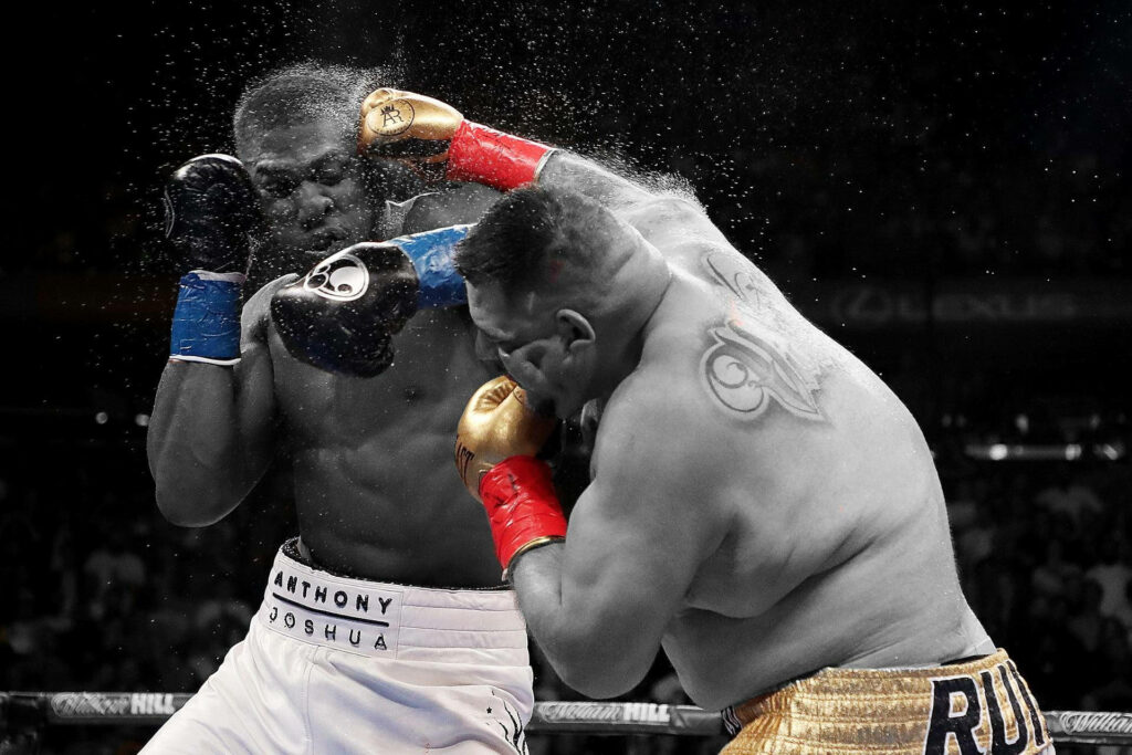 Anthony Joshua defending against powerful punch from Andy Ruiz Jr in intense boxing match wallpaper