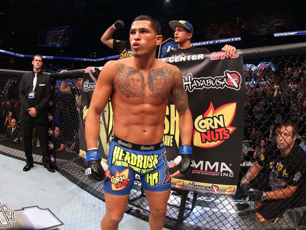 Anthony Pettis in MMA cage showing athletic physique fighter shorts fight stats intense arena background Wallpaper