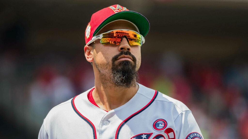 Anthony Rendon in baseball uniform wearing vibrant colorful sunglasses against wallpaper background