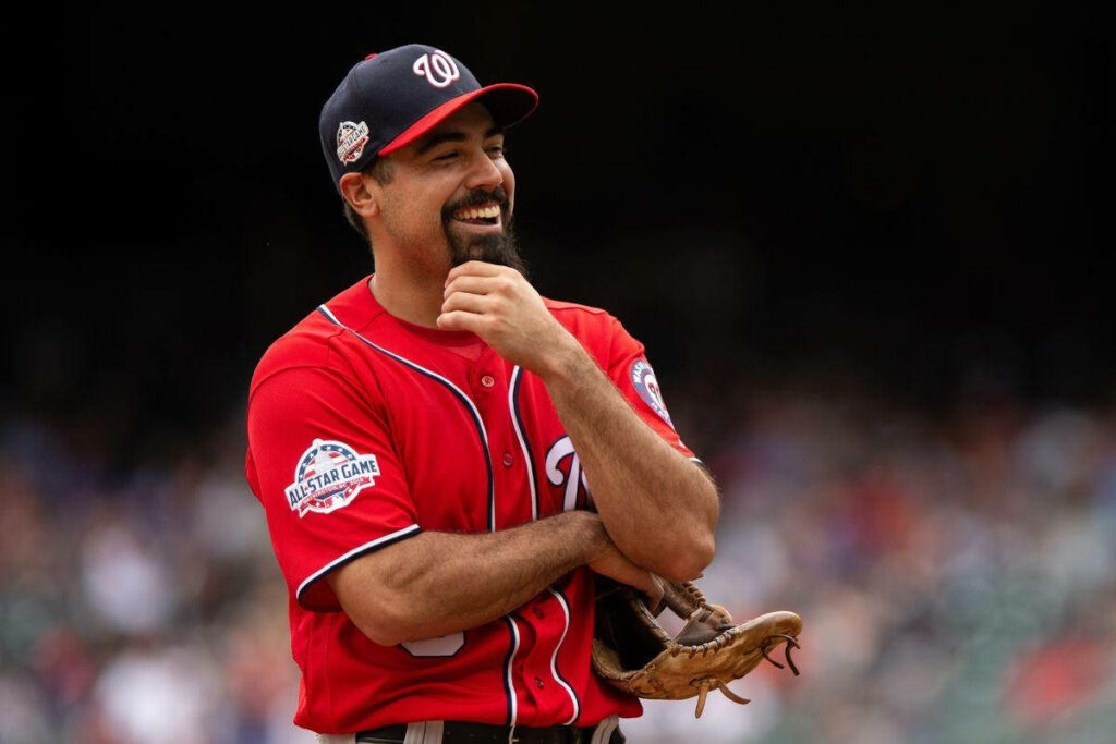 Anthony Rendon in Washington Nationals uniform smiling thoughtfully on baseball field wallpaper background