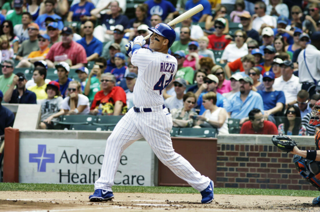 Anthony Rizzo powerful swing at the plate Chicago Cubs game enthusiastic stadium crowd wallpaper