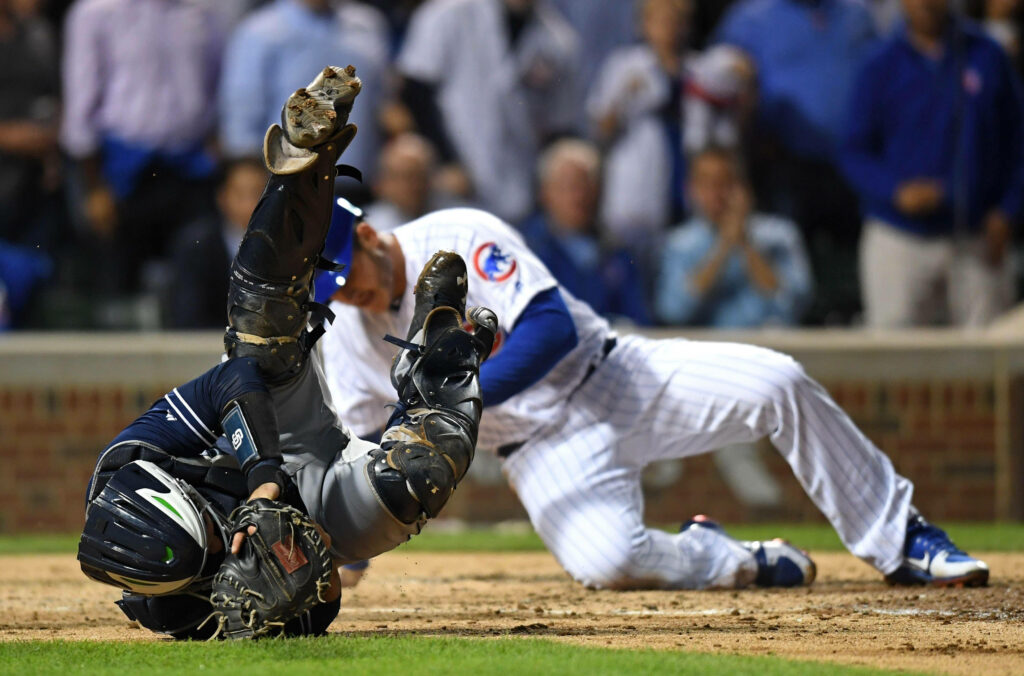 Anthony Rizzo slides into home plate as catcher in full gear kneels during intense baseball game action Wallpaper